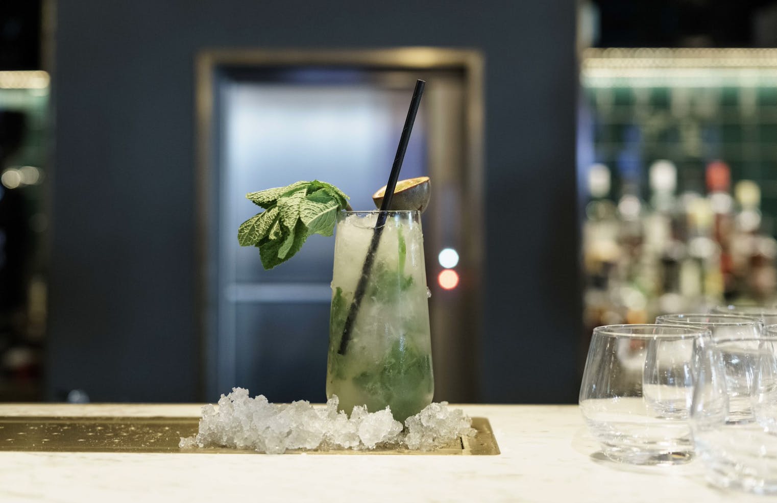 An ice passionfruit mojito is artfully displayed on the bar top.