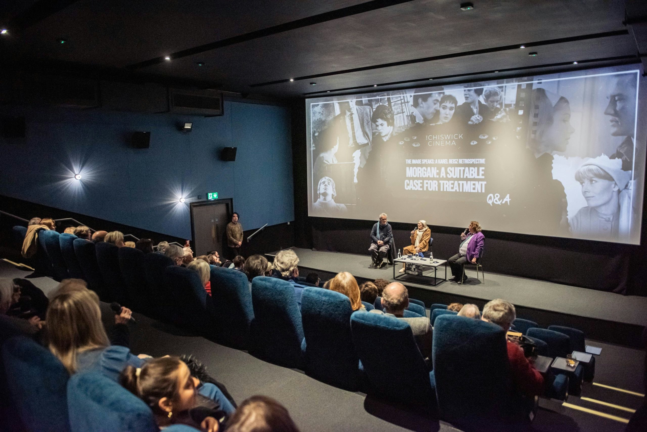 Vanessa Redgrave and Stephen Frears sit on stage watched in discussion by a captive audience.