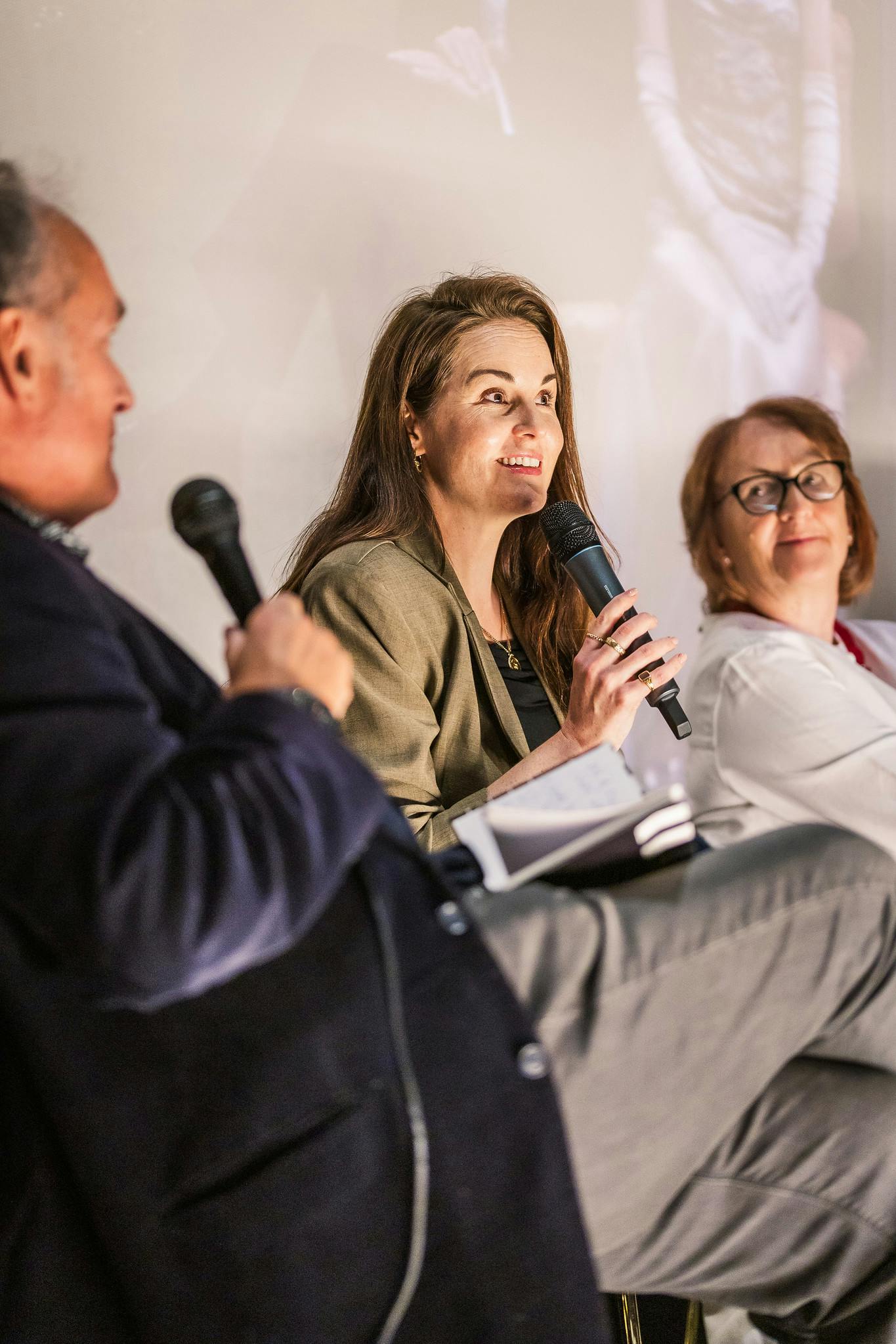 Michelle Dockery smiles while speaking to a cinema audience.