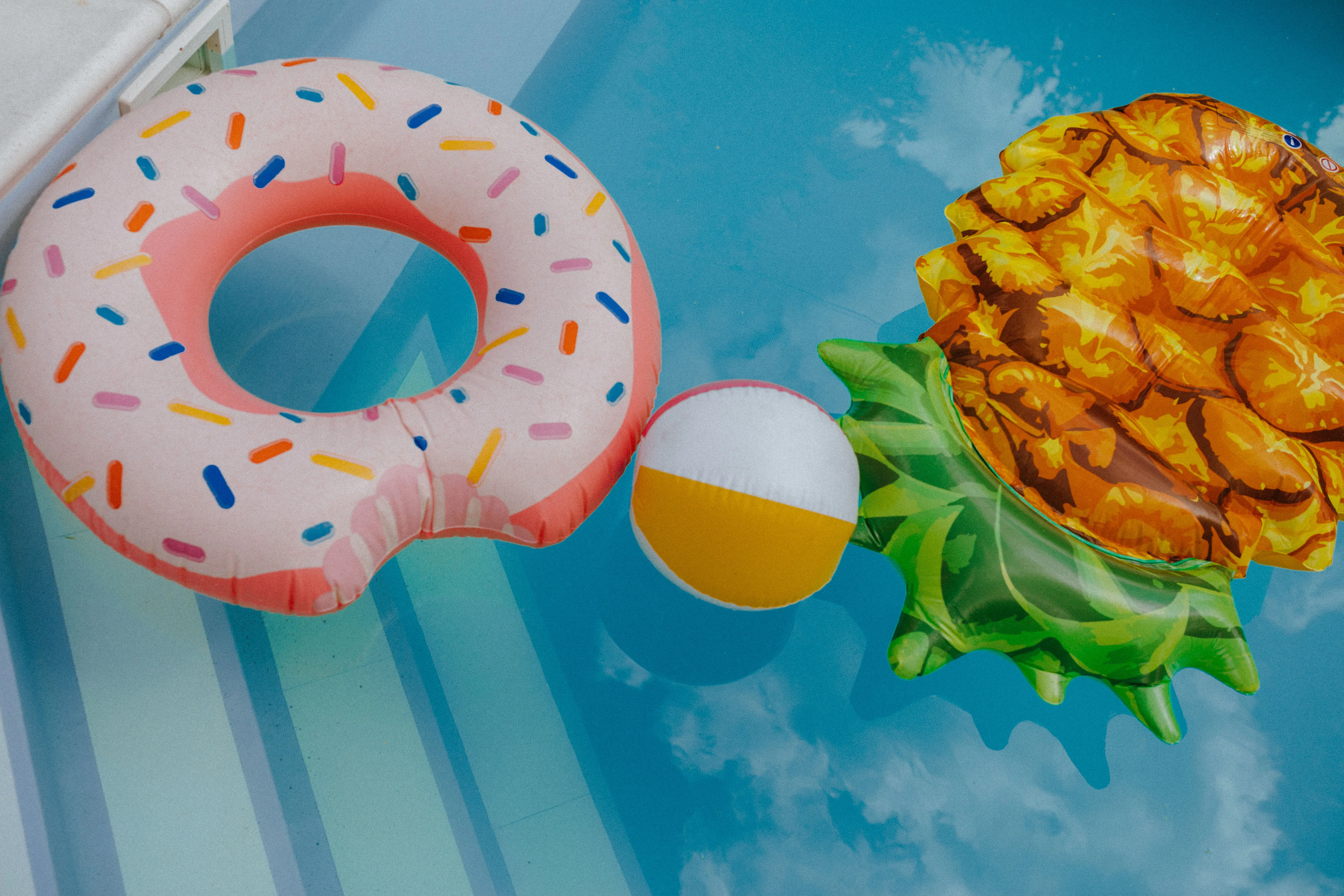 Pool party donut, beach ball, and pineapple shaped pool floaties