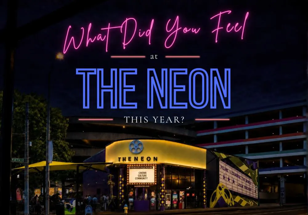 Promo graphic asking 'What Did You Feel at The Neon This Year?' in neon-style pink and blue lettering, over a nighttime photo of The Neon movie theater. The lit marquee reads 'Cinema, Culture, Community,' with a parking structure behind and a filmreel mural on the right.
