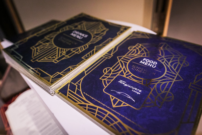 A panel of celebrity guests talks to a full audience on stage.