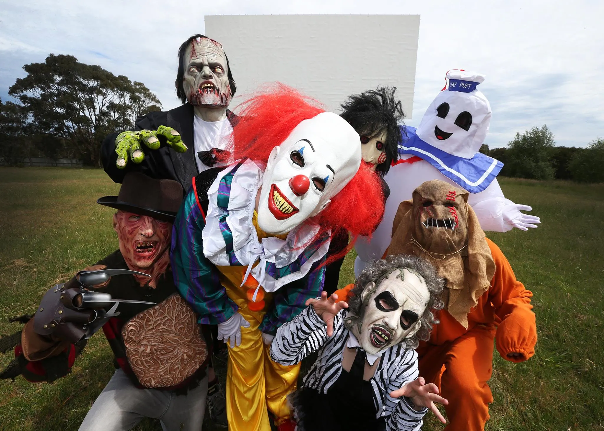 People in costumes infront of Drive-In screen