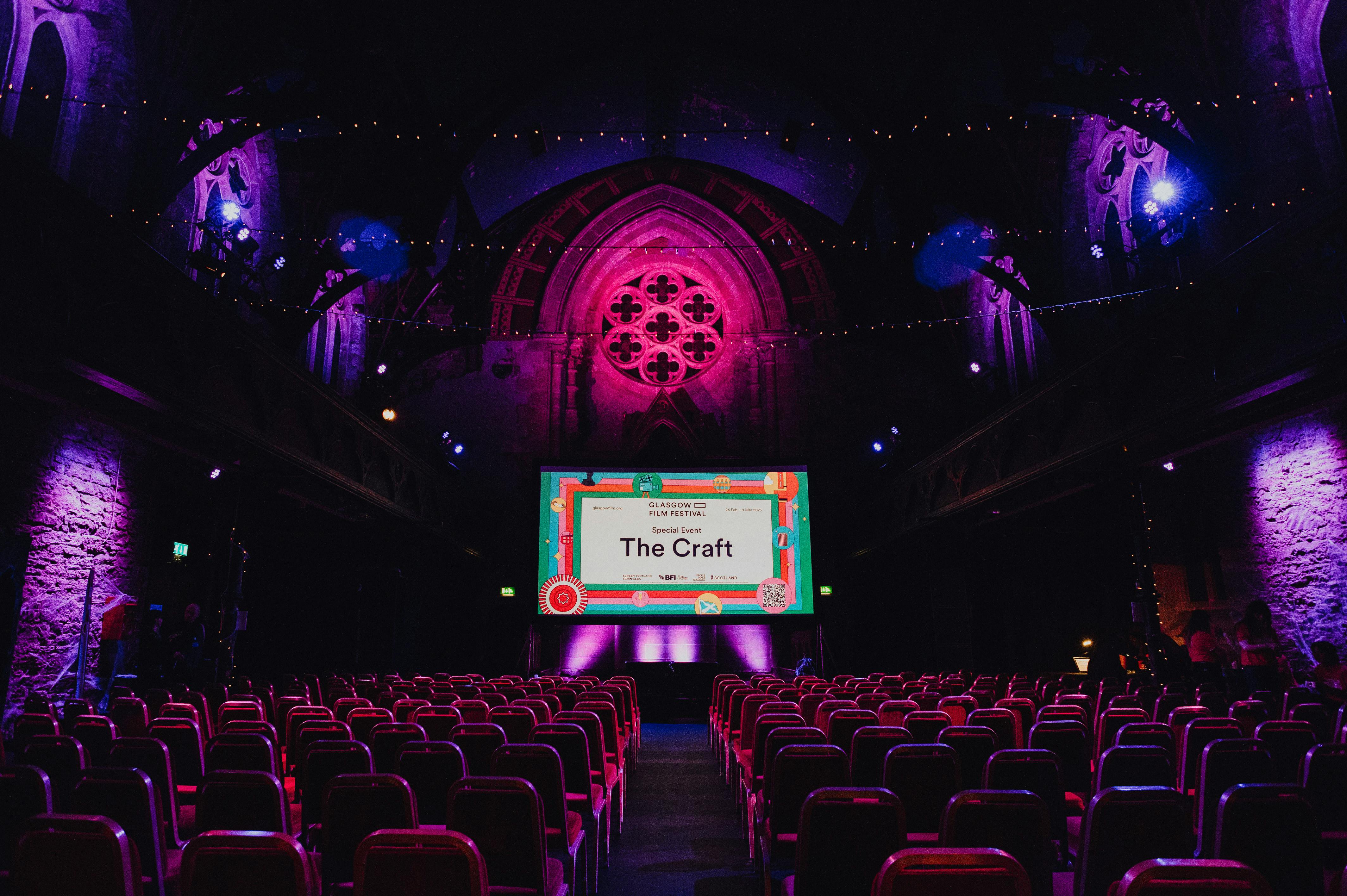 Empty theatre seats lit by blue light before a screening