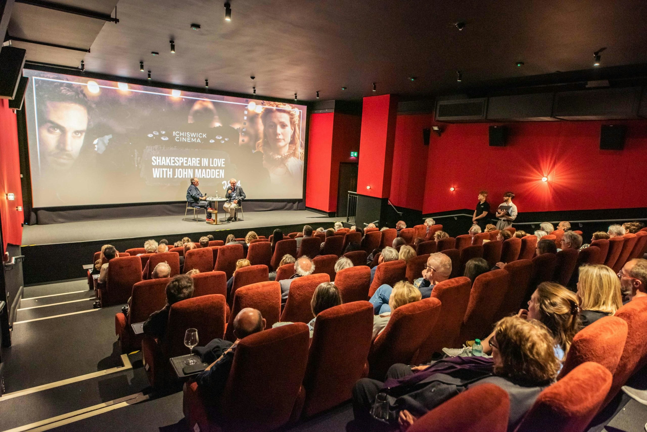 A full cinema audience enjoys seeing John Madden on stage talking about Shakespeare in Love.