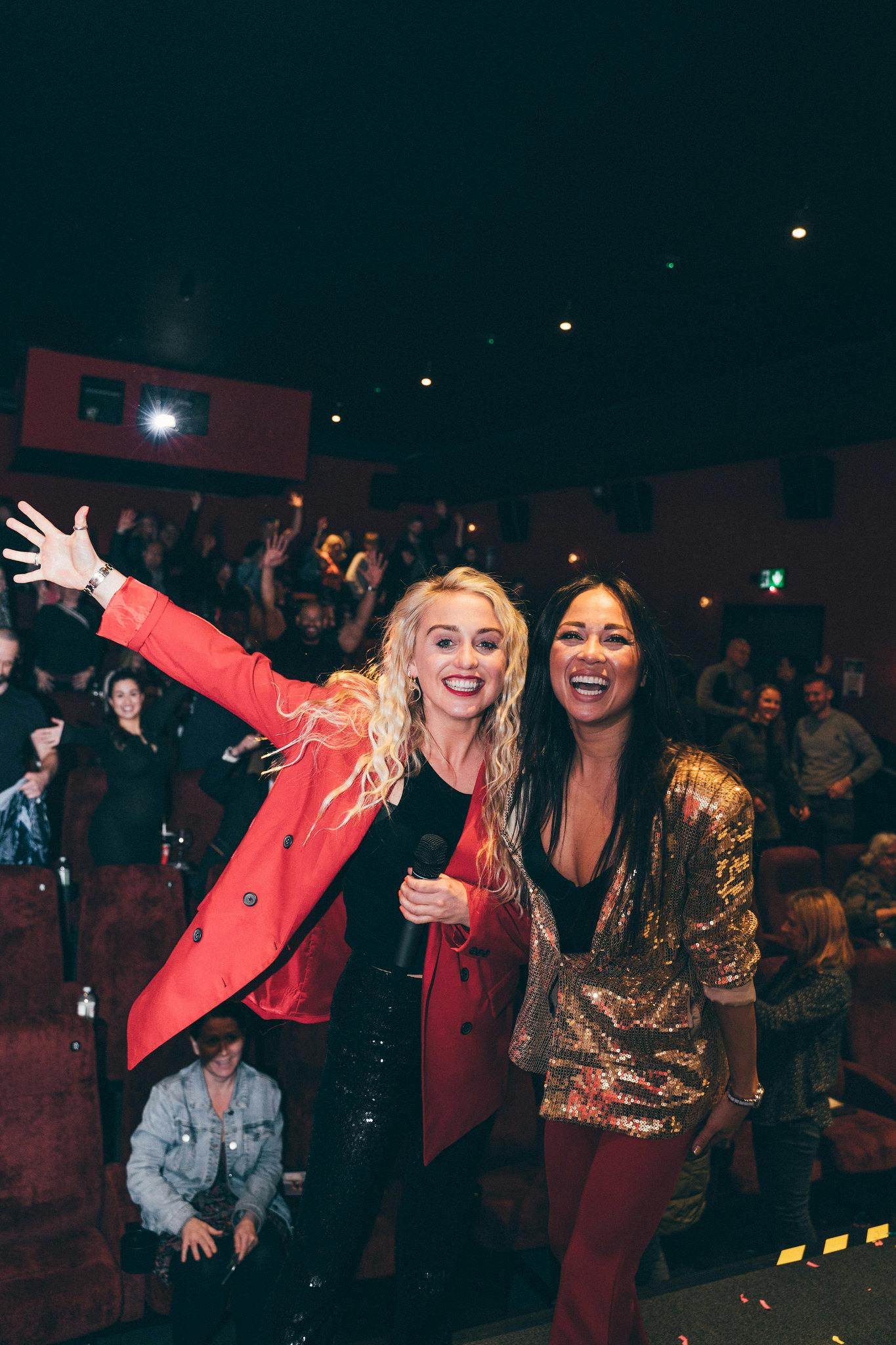 Katya Jones and Aimee Fuller smile with a screen full of guests.