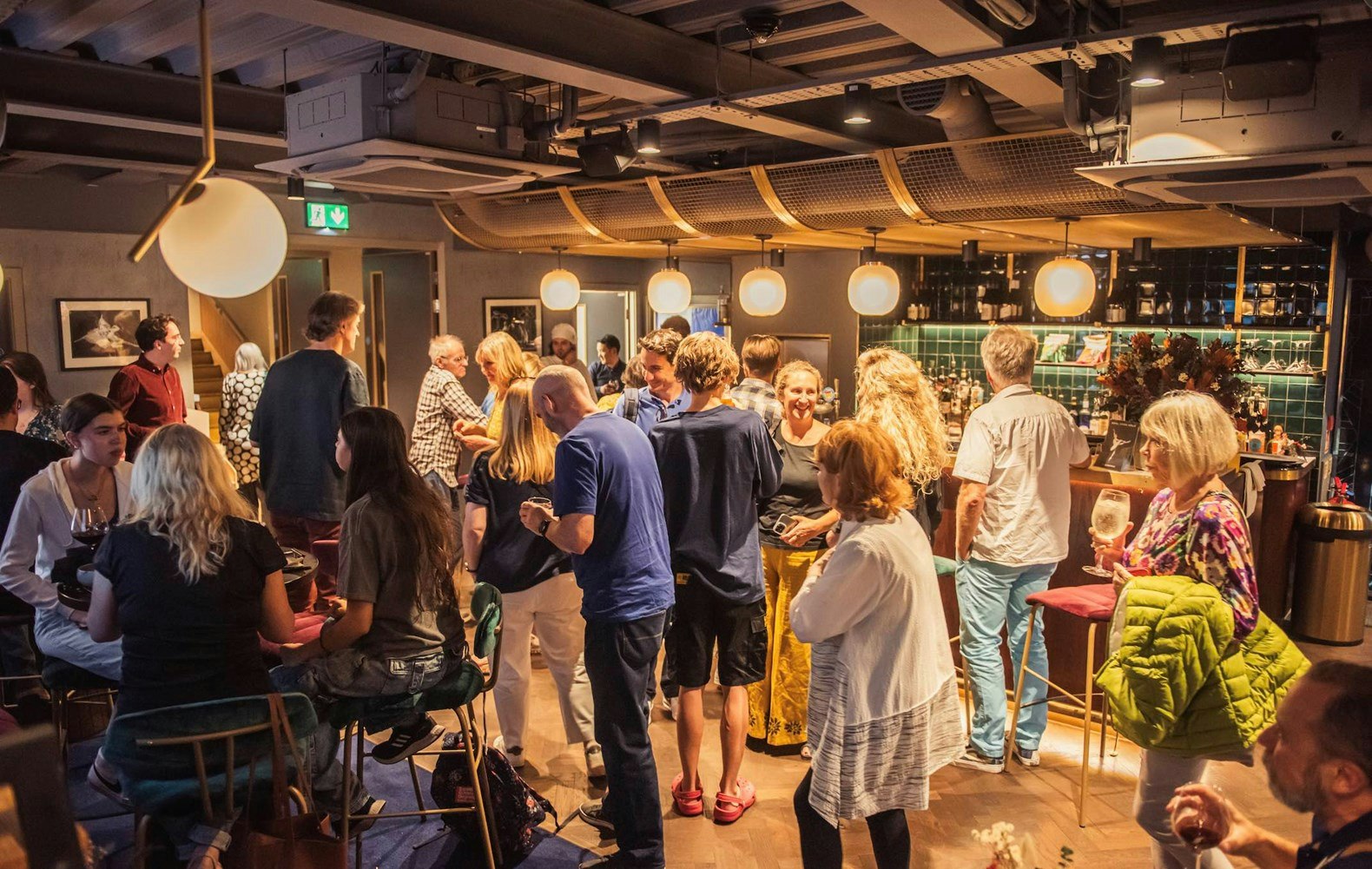 Guests mingle and smile and drink in a busy Lounge bar.