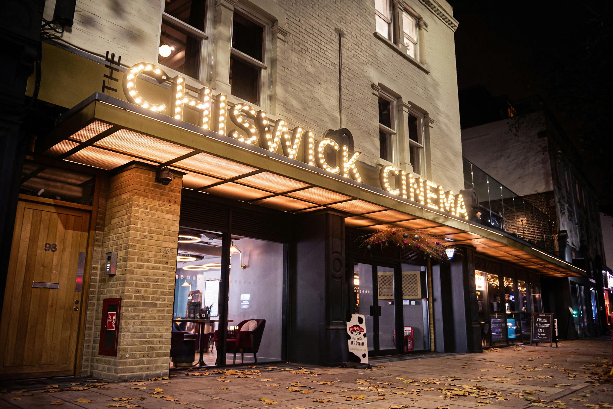 The exterior of The Chiswick Cinema with a bold lightbulb sign.
